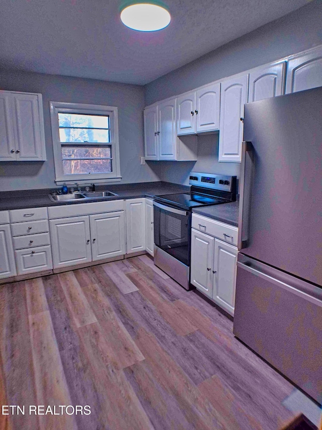 705 S 11th St, Lafollette, TN 37766 - kitchen featuring appliances with stainless steel finishes, dark countertops, white cabinets, and light wood-type flooring