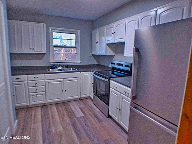 705 S 11th St, Lafollette, TN 37766 - kitchen with appliances with stainless steel finishes, white cabinetry, dark countertops, and dark wood-type flooring