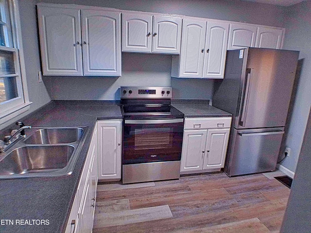 705 S 11th St, Lafollette, TN 37766 - kitchen featuring appliances with stainless steel finishes, white cabinetry, dark countertops, and light wood-style floors