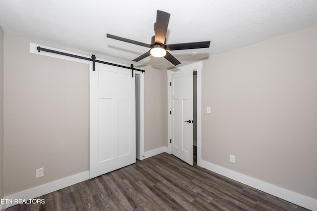 957 W Hunt Rd, Alcoa, TN 37701 - unfurnished bedroom featuring a barn door, dark wood finished floors, and ceiling fan