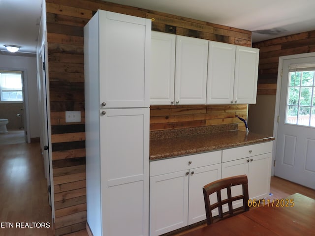 110 Dale Rd, Oakdale, TN 37829 - kitchen with light wood-style flooring, white cabinets, wooden walls, and dark stone countertops