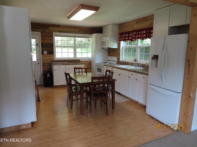 110 Dale Rd, Oakdale, TN 37829 - kitchen with white appliances, light wood-type flooring, white cabinets, wooden walls, and dark countertops