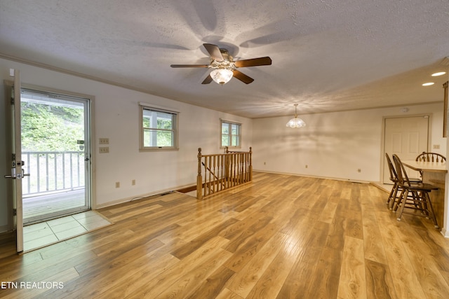 609 Lane Hollow Rd, Sevierville, TN 37876 - unfurnished living room with light wood finished floors, ceiling fan, a textured ceiling, a chandelier, and crown molding