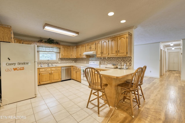 609 Lane Hollow Rd, Sevierville, TN 37876 - kitchen featuring white appliances, under cabinet range hood, a peninsula, light countertops, and a kitchen bar