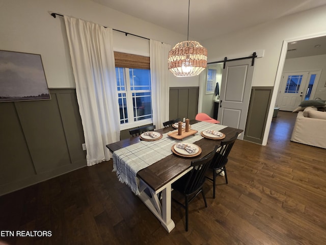 6312 Knightsboro Rd, Knoxville, TN 37912 - dining area featuring a barn door, a decorative wall, a chandelier, dark wood-style flooring, and wainscoting
