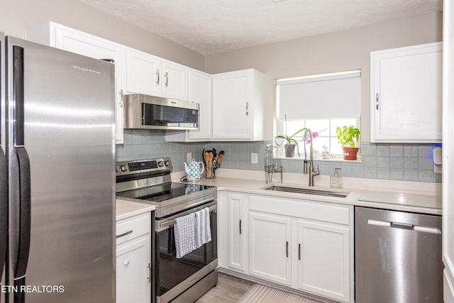 2544 Bay Meadows Way, Sevierville, TN 37876 - kitchen with appliances with stainless steel finishes, light countertops, white cabinetry, backsplash, and a textured ceiling