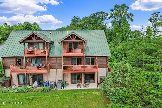 152 Eagle Crst, Tazewell, TN 37879 - back of property featuring a balcony, a patio area, a lawn, a metal roof, and brick siding