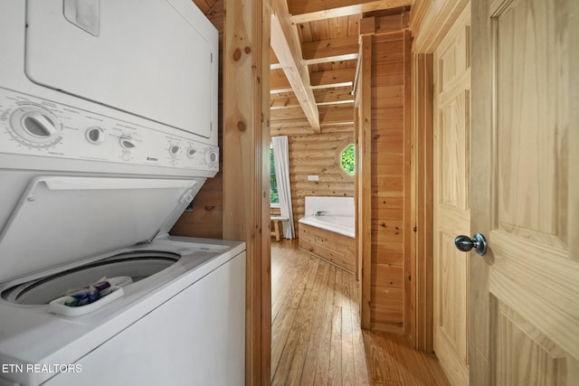 3319 Covered Bridge Way, Sevierville, TN 37862 - laundry room with estacked washer and dryer, log walls, and light wood-style flooring