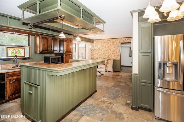 146 Lake Hills Dr, Oak Ridge, TN 37830 - kitchen featuring appliances with stainless steel finishes, green cabinets, a chandelier, wallpapered walls, and light stone finish floors