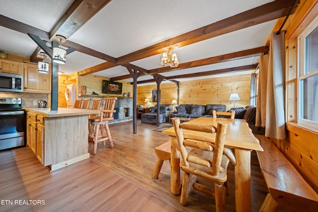 1516 Zurich Rd, Gatlinburg, TN 37738 - dining space featuring wooden walls, light wood-style floors, beamed ceiling, a chandelier, and a textured ceiling