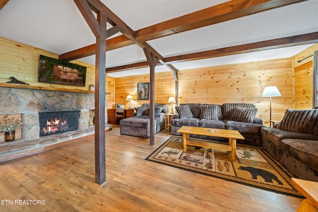1516 Zurich Rd, Gatlinburg, TN 37738 - living room featuring beam ceiling, wooden walls, a fireplace, and wood finished floors