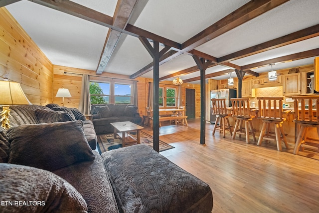 1516 Zurich Rd, Gatlinburg, TN 37738 - living room featuring wood walls, light wood-style floors, beamed ceiling, and a chandelier