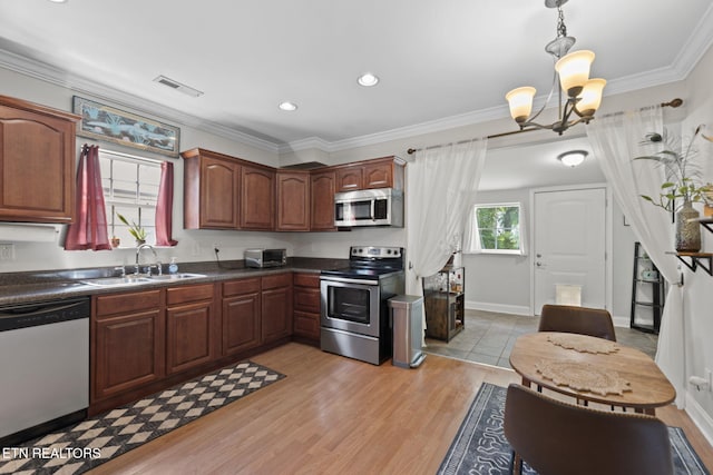 1132 Connecticut Ave, Knoxville, TN 37921 - kitchen featuring stainless steel appliances, dark countertops, a chandelier, ornamental molding, and pendant lighting