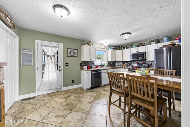 155 Kay Springs Cir, Jacksboro, TN 37757 - kitchen featuring stainless steel appliances, decorative backsplash, white cabinets, light countertops, and a textured ceiling