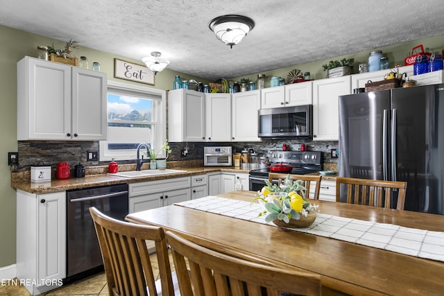 155 Kay Springs Cir, Jacksboro, TN 37757 - kitchen featuring appliances with stainless steel finishes, backsplash, white cabinetry, and a textured ceiling