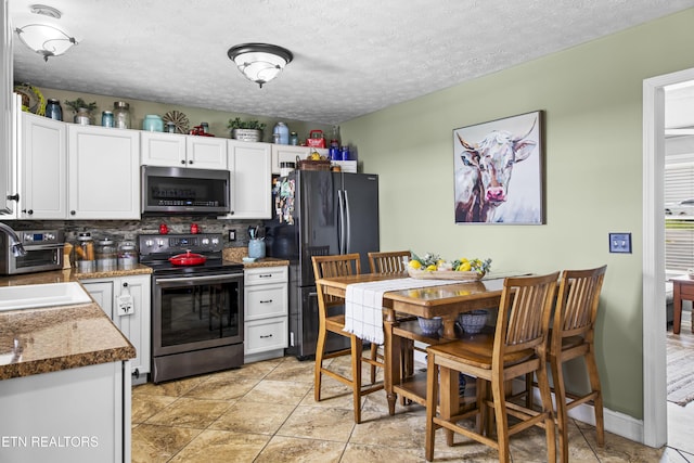 155 Kay Springs Cir, Jacksboro, TN 37757 - kitchen featuring stainless steel electric range, freestanding refrigerator, tasteful backsplash, white cabinets, and light tile patterned floors
