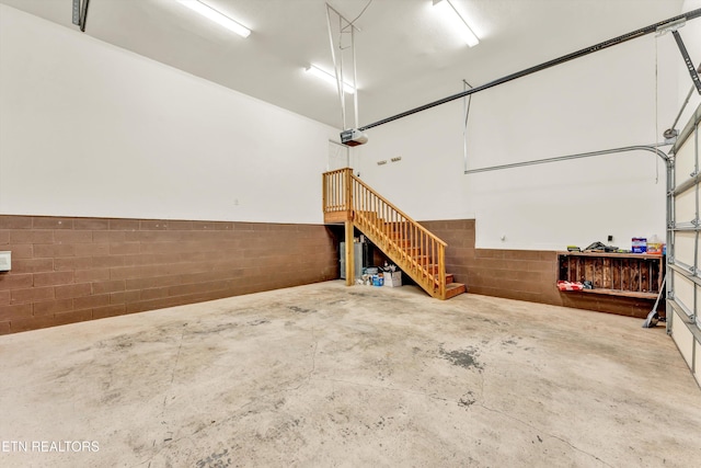 235 Jessie Ln, Lenoir City, TN 37772 - garage featuring concrete block wall, a garage door opener, and a wainscoted wall