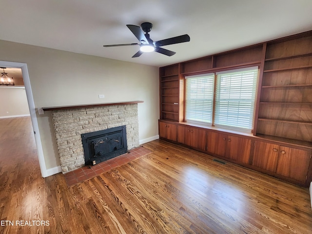 212 Ellison Rd, Lafollette, TN 37766 - unfurnished living room with built in features, a fireplace with flush hearth, ceiling fan, and wood finished floors