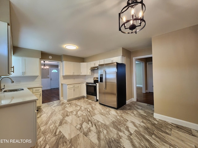 212 Ellison Rd, Lafollette, TN 37766 - kitchen featuring appliances with stainless steel finishes, a chandelier, light countertops, white cabinets, and under cabinet range hood