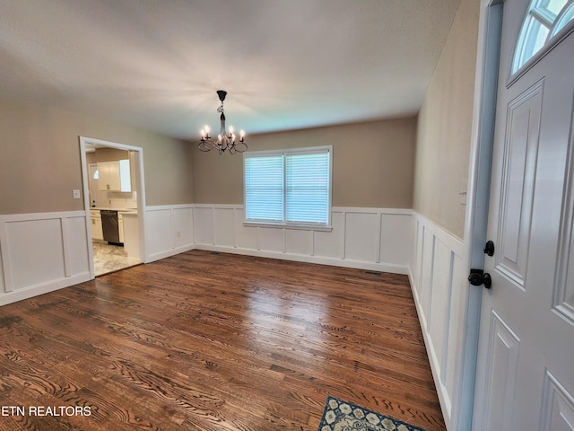 212 Ellison Rd, Lafollette, TN 37766 - unfurnished dining area featuring a chandelier, a wainscoted wall, and dark wood-style floors