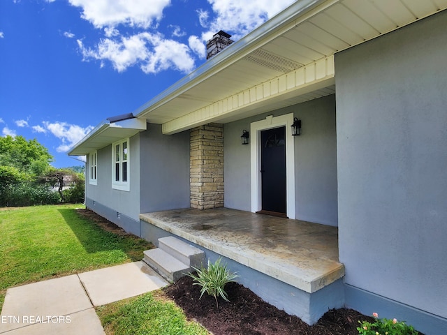 212 Ellison Rd, Lafollette, TN 37766 - view of exterior entry with a porch, a yard, a chimney, and stucco siding