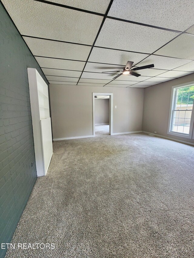 918 5th St, Jellico, TN 37762 - empty room featuring carpet flooring, a ceiling fan, a paneled ceiling, and brick wall