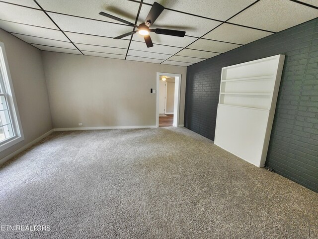 918 5th St, Jellico, TN 37762 - unfurnished bedroom featuring carpet floors, brick wall, and a drop ceiling