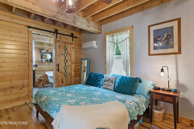 187 Persimmon Ln, Pioneer, TN 37847 - bedroom with an AC wall unit, a barn door, wood walls, hardwood / wood-style floors, and beamed ceiling