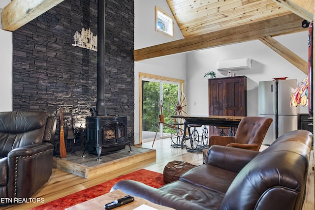 187 Persimmon Ln, Pioneer, TN 37847 - living room with high vaulted ceiling, wood finished floors, a wood stove, a wall mounted AC, and plenty of natural light