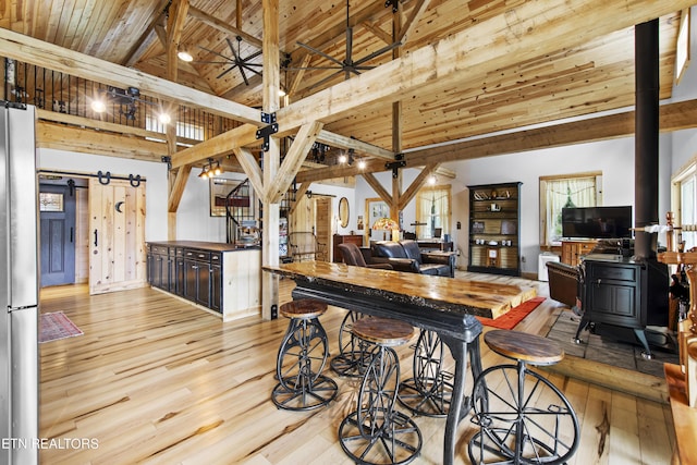 187 Persimmon Ln, Pioneer, TN 37847 - kitchen featuring wooden ceiling, freestanding refrigerator, a barn door, wood finished floors, and a wood stove