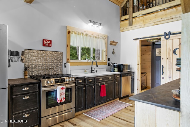 187 Persimmon Ln, Pioneer, TN 37847 - kitchen featuring stainless steel appliances, a barn door, light wood finished floors, and dark cabinets
