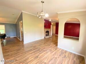 2517 Shields Ferry Rd, Morristown, TN 37814 - unfurnished living room with ornamental molding, a chandelier, wood finished floors, and a fireplace with raised hearth
