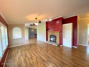 2517 Shields Ferry Rd, Morristown, TN 37814 - unfurnished living room featuring ceiling fan, crown molding, wood finished floors, and a fireplace with raised hearth