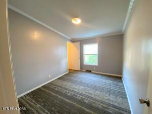2517 Shields Ferry Rd, Morristown, TN 37814 - spare room featuring ornamental molding and dark wood-style floors
