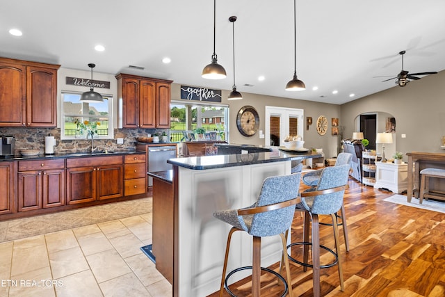 1045 Southwind Cir, Dandridge, TN 37725 - kitchen featuring dishwasher, a breakfast bar, a kitchen island, arched walkways, and tasteful backsplash