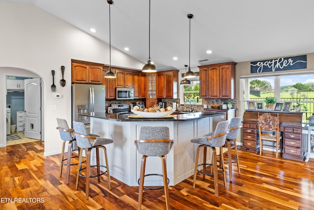 1045 Southwind Cir, Dandridge, TN 37725 - kitchen with stainless steel appliances, dark wood-type flooring, lofted ceiling, a kitchen bar, and a kitchen island