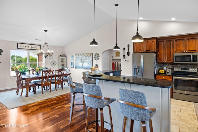 1045 Southwind Cir, Dandridge, TN 37725 - kitchen with stainless steel appliances, arched walkways, a breakfast bar area, backsplash, and a center island