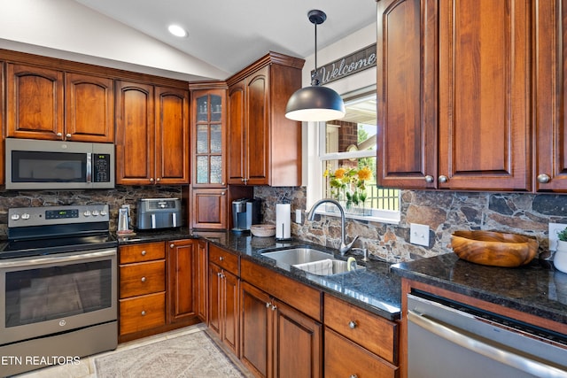 1045 Southwind Cir, Dandridge, TN 37725 - kitchen with appliances with stainless steel finishes, vaulted ceiling, dark stone counters, decorative backsplash, and hanging light fixtures