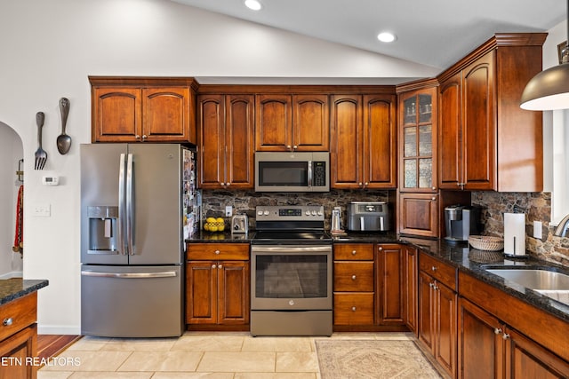 1045 Southwind Cir, Dandridge, TN 37725 - kitchen with stainless steel appliances, lofted ceiling, backsplash, dark stone counters, and arched walkways