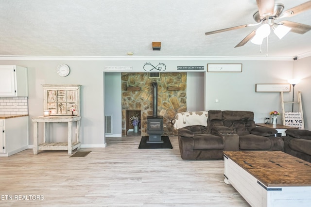 1820 Locust Grove Rd, New Tazewell, TN 37825 - living area featuring ornamental molding, a wood stove, light wood-style floors, and a ceiling fan