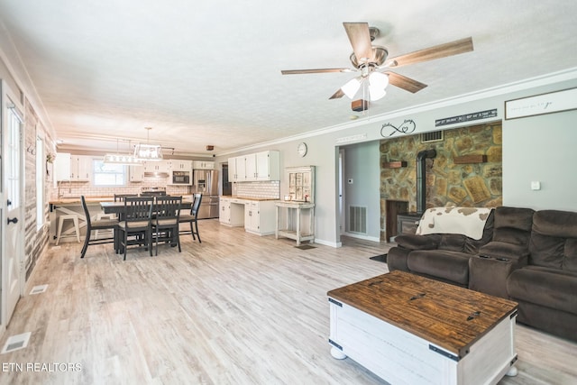 1820 Locust Grove Rd, New Tazewell, TN 37825 - living area with a wood stove, ceiling fan, crown molding, and light wood finished floors