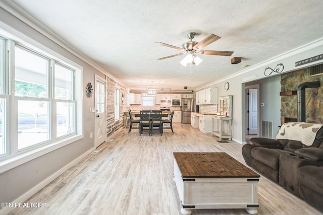 1820 Locust Grove Rd, New Tazewell, TN 37825 - living area with a wood stove, a textured ceiling, a ceiling fan, crown molding, and healthy amount of natural light