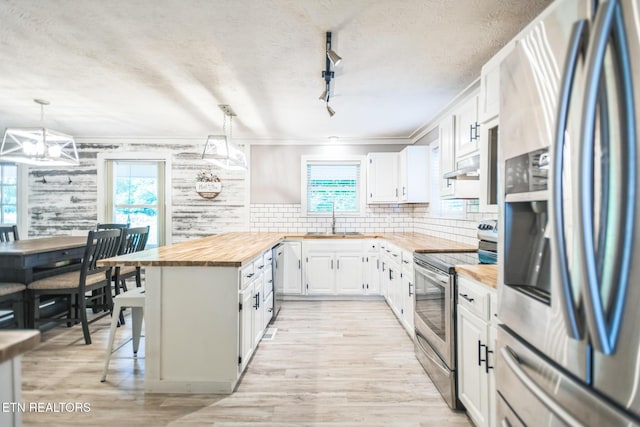 1820 Locust Grove Rd, New Tazewell, TN 37825 - kitchen featuring appliances with stainless steel finishes, wooden counters, plenty of natural light, a textured ceiling, and under cabinet range hood