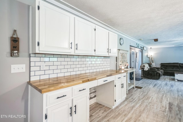 1820 Locust Grove Rd, New Tazewell, TN 37825 - kitchen featuring wood counters, a textured ceiling, light wood-type flooring, white cabinetry, and tasteful backsplash
