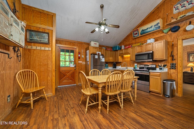 719 Kings Hills Blvd, Pigeon Forge, TN 37863 - dining space featuring wooden walls, vaulted ceiling, dark wood-type flooring, ceiling fan, and a textured ceiling