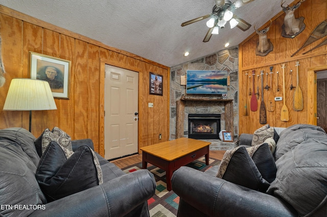 719 Kings Hills Blvd, Pigeon Forge, TN 37863 - living area with wood finished floors, lofted ceiling, a ceiling fan, wood walls, and a stone fireplace