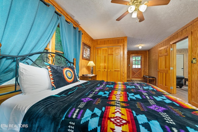 719 Kings Hills Blvd, Pigeon Forge, TN 37863 - bedroom with a textured ceiling, wooden walls, and ceiling fan