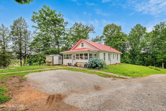 5750 E Lee Hwy, Loudon, TN 37774 - view of front of house featuring a storage shed, a metal roof, and a front yard