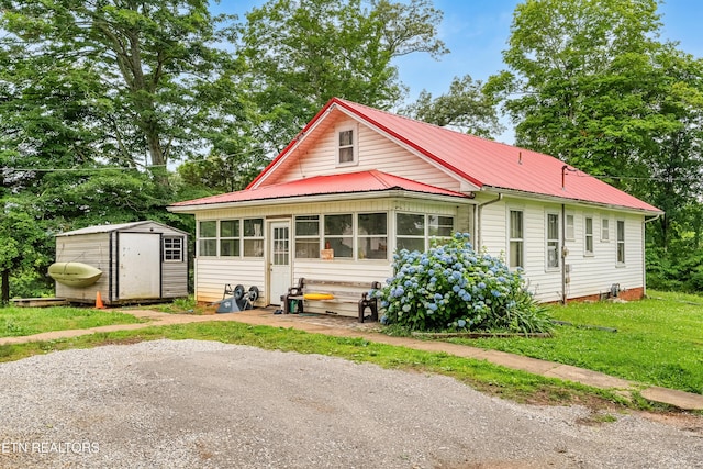 5750 E Lee Hwy, Loudon, TN 37774 - view of front facade with a shed, a sunroom, a metal roof, and a front lawn
