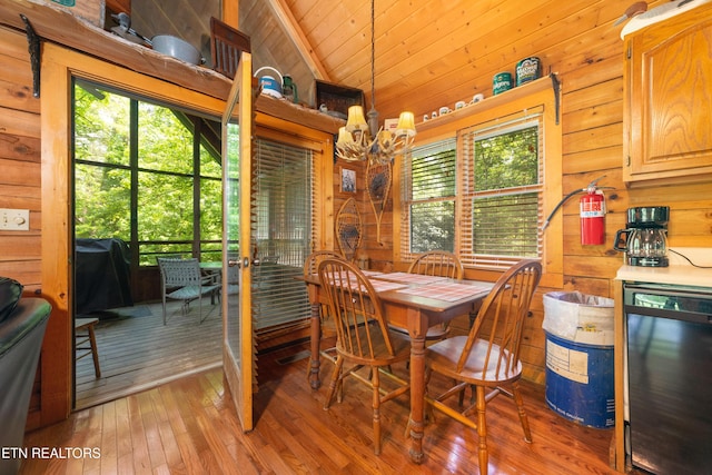 2389 Misty Ln, Sevierville, TN 37876 - dining room with a chandelier, wooden walls, light wood-type flooring, wood ceiling, and lofted ceiling